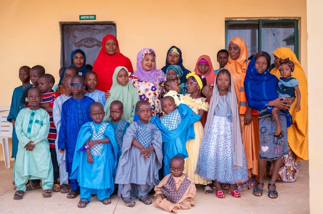 Bilkisu Nasir with children and caregivers at a community support visit