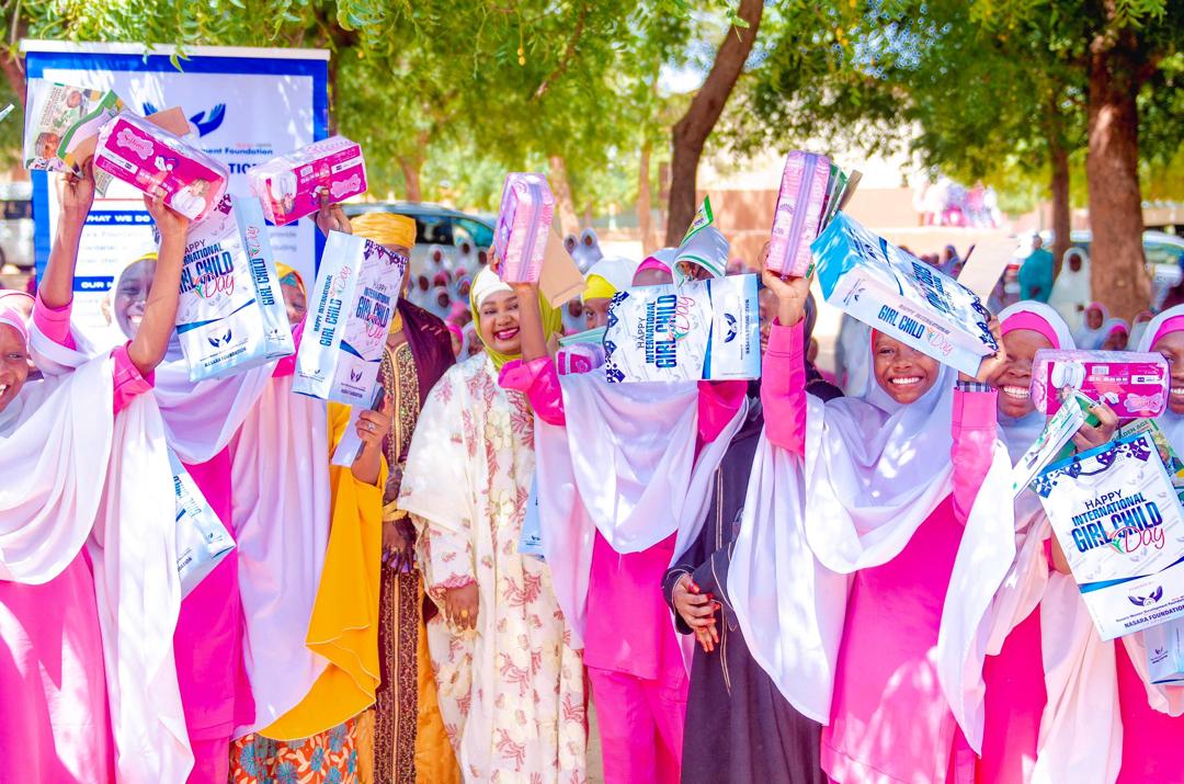 Schoolgirls celebrating with educational and personal-care packages